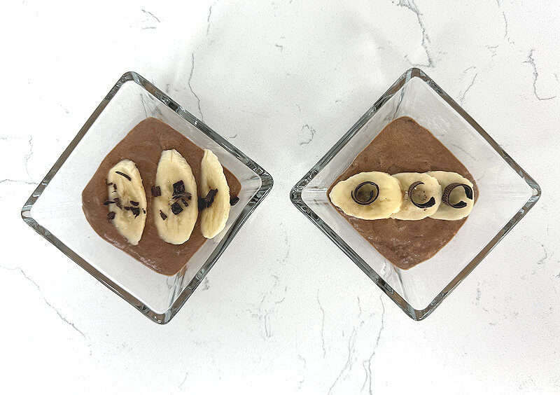 Top down image of banana chocolate mouse in glass square bowls