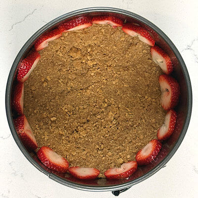 Step 3 - If you prefer to do so, slice the strawberries thinly and arrange the slices around the edge of the prepared tin, top facing up.