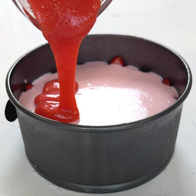 Step 6 - Pour the strawberry sauce over the top of the cooled cheesecake. Place the cheesecake back in the refrigerator and cool for another hour to set the topping.