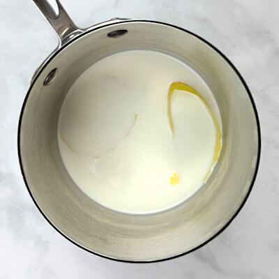 Step 2 - Combine in a saucepan, rest of the milk, half and half, cream, sugar, lemon peel and vanilla bean (scrape the seeds from the pod and add seeds and pod). Bring to a simmer and whisk until the sugar is dissolved. Take pan from the heat and rest for 10 minutes.
