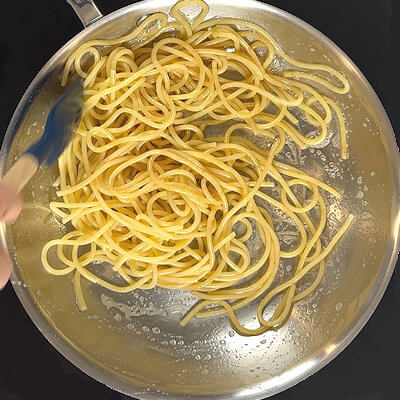 Step 3 - Drain the pasta and reserve some of the pasta water. Add the pasta to the skillet and toss to coat the pasta with the butter.