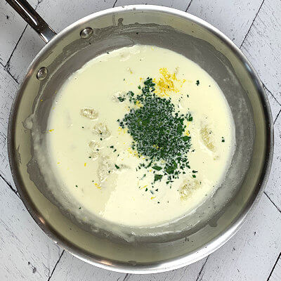 Step 2 - Add lemon juice, half of lemon zest and half of chopped parsley to the cream and mix.