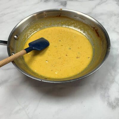 Step 2 - Make the orange cream, by adding the cream, orange juice and most of orange zest to the same skillet. Bring that to a simmer and cook until it is thickening just slightly.