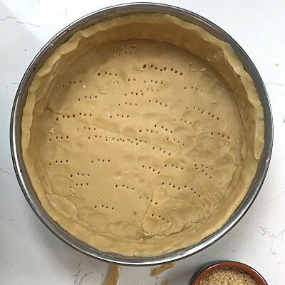 Step 4 - Grease a 9-inch spring form with butter. Cut 1/3 off the dough for the lattice. Roll the rest of the dough out and cover bottom and sides. Poke holes in the bottom with a fork.