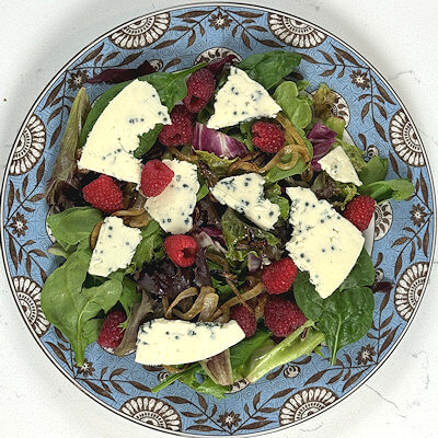Step 3 - Cut the blue cheese in thin slices, break those slices and divide them over the plates. I prefer slices of blue cheese for this salad over crumbles, because it adds to the beauty of the salad.