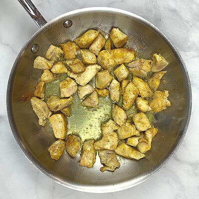 Step 2 - Cut the chicken fillets in small cubes, season with salt, pepper and curry powder.Heat the oil and cook the chicken for approx. 3 minutes.