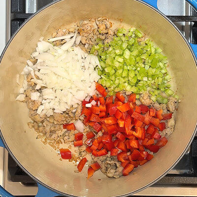 Step 2 - Add finely chopped onion, celery and red bell pepper and saute these until that start to soften. If you want to add garlic to the soup, this is the time to do it.