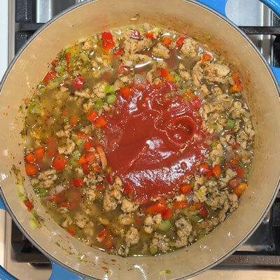 Step 4 - Add chicken stock and passata and bring to a simmer.