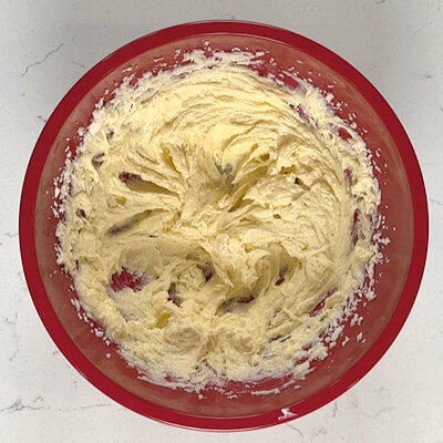 Step 2 - Add 1/2 egg (beaten) and a pinch of salt and mix again. Reserve a little bit of the egg to brush the top of the boterkoek in step 5.