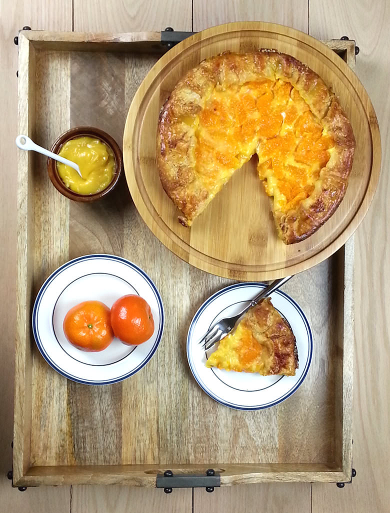 Mandarin Lemon Curd Pie cut with small bowl of lemon curd and 2 mandarins.