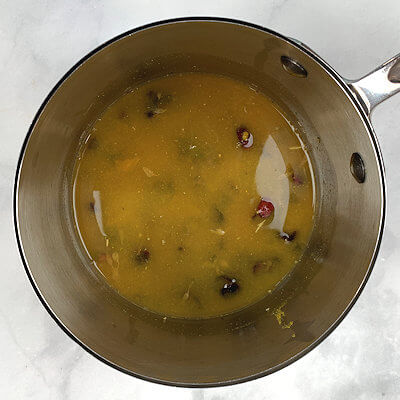 Step 2 - In a small sauce pan, bring orange juice and chicken stock to a boil. Remove from heat, add cranberries and curry powder.