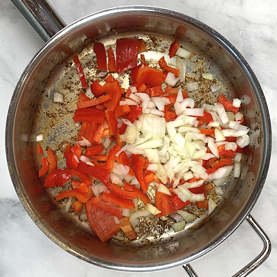 Step 3 - Heat olive oil in the same skillet as the chicken and add garlic paste, onion and bell pepper. Saute for a couple of minutes.