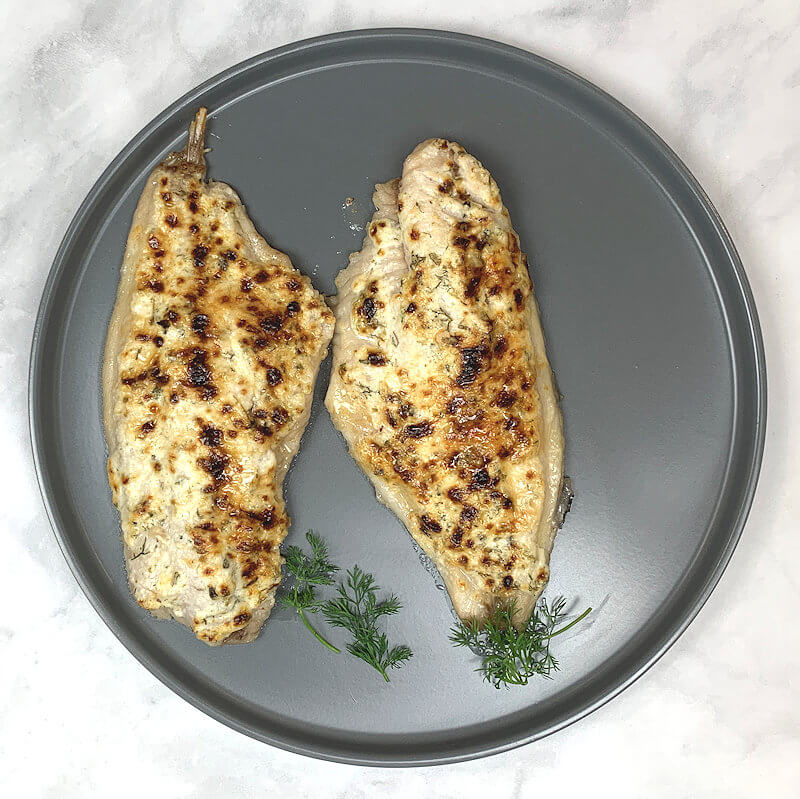 Grey round plate with 2 broiled catfish fillets