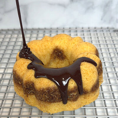 Step 6 - Take the cake out of the bundt pan and allow to cool. Make the chocolate glaze by mixing powdered sugar with cocoa powder, vanilla extract and milk. Drizzle this over the cake and allow the glaze to run down the inner and outer side of the cake for maximum effect.