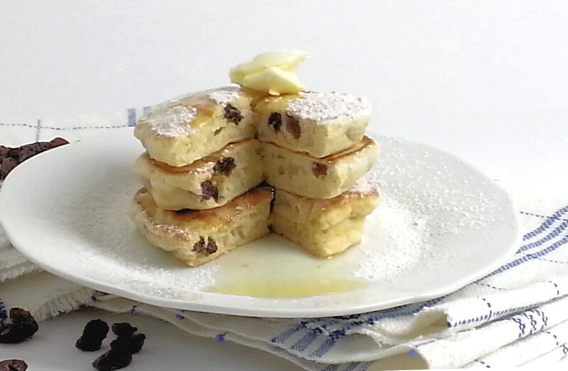 Small pancakes stacked and a quarter cut out.