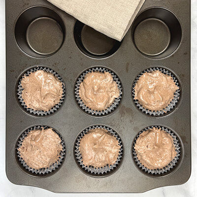 Step 4 - Place 6 cupcake liners in a cupcake pan. Divide the batter over these 6 liners and smooth the top a  little. Bake 13-15 minutes in an oven of 350°F. Allow to cool.       