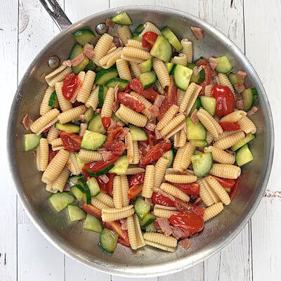 Step 3 - Drain the pasta and add it to the vegetables in the skillet and mix.