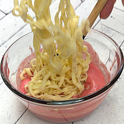 Step 3- Cook the pasta with the granulated sugar according to the directions on the packaging. Drain and rinse in a colander until cold. Mix the pasta with the strawberry sauce and divide over 2 bowls.