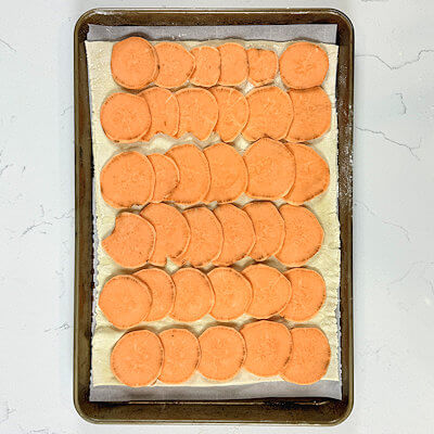 Step 2 - Cover the pastry dough with thin slices of sweet potato. Allow them to overlap.