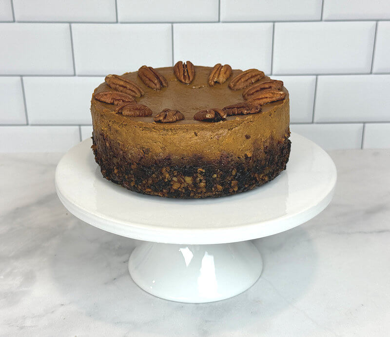 Image of an uncut pumpkin pie on date-pecan crust.