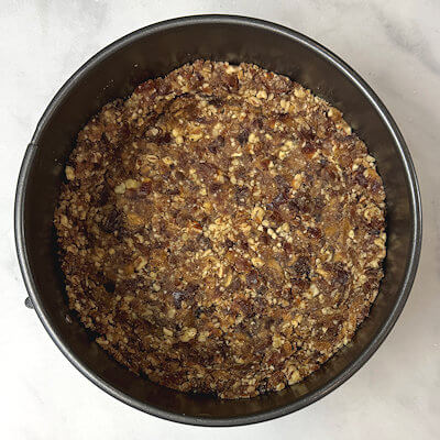 Step 1 - Pit the dates, cut them in half and transfer them together with the pecans to a food processor and pulse until fine. Cover the bottom of the 6-inch springform with parchment paper. Firmly press the nut-date mixture onto the bottom of the pan and about halfway up the side.