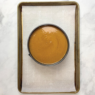 Step 5 - Pour the warm mixture into the springform. Place the springform on a baking sheet lined with parchment paper. (some leakage may occur). Place the pie into a 400°F oven for 10 minutes. The lower the temperature to 300°F and bake for another 60-65 minutes.