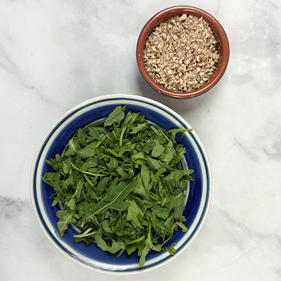 Step 3 - Chop the arugula just a little bit and chop the pecan fine.