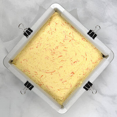 Step 5 - Add the semolina and fold with the spatula until incorporated. In steps, scoop the whipped egg whites onto the mixture and gently fold them until no white streaks remain. Transfer batter into the baking pan, gently spread into a smooth, even layer.