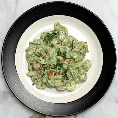 Step 5 - Divide the pasta over 2 plates and garnish with basil and roasted pine nuts.