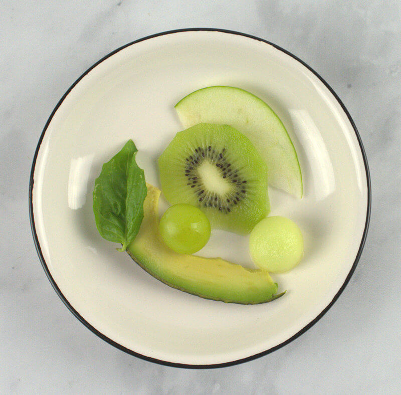 Small white plate with slices of each fruit.