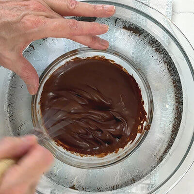 Step 4 - Prepare an ice bath by filling a bowl with water and lots of ice cubes. Place a smaller bowl inside the bowl with the water and pour the melted chocolate into the smaller bowl. Whisk the chocolate by hand until the chocolate thickens. This will take about 15 minutes.