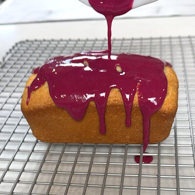 Step 7 - Make the blueberry glaze by cooking the blueberries with 1/2 tablespoon of water, and the lemon juice, until the blueberries burst. Puree the berries and add the powdered sugar to achieve your desired consistency. Allow the glaze to cool a little and pour over the cake. Allow to run down the sides for a more dramatic effect.
