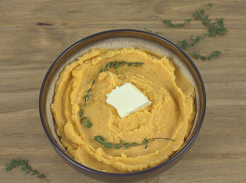 Angled bowl with pumpkin mashed potatoes with thyme and butter.
