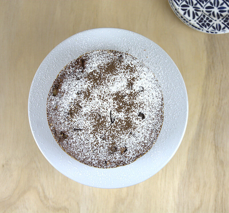 A top-down image of the chocolate pear cake. Looking at a dusting of sugar and cocoa powder.