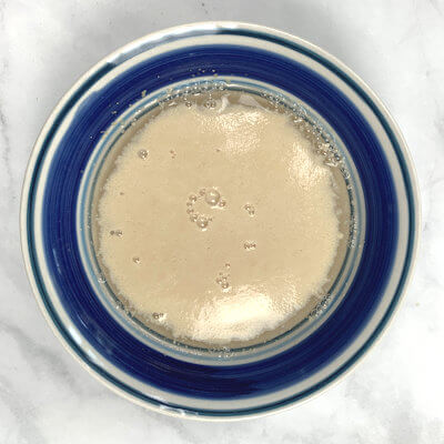 Step 1 - Wake up and feed the yeast by adding it to lukewarm water with just a tiny pinch of sugar. 