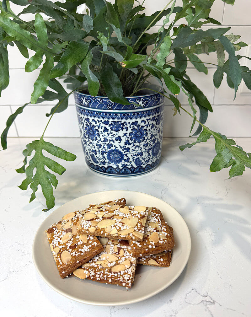 Dish with cookies with fern in the background.