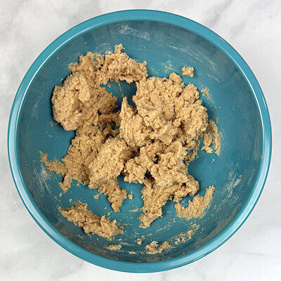 Step 3 - Add flour mixture to butter mixture. You'll end up with a slightly crumbly mixture that easily comes together pressure is applied. If the mixture is too soft to roll out, place it in the fridge for about an hour.