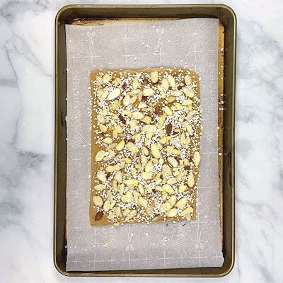 Step 5 - Sprinkle the dough with almond slivers and pearl sugar. Press the topping gently into the dough. Use your hands or a rolling pin.