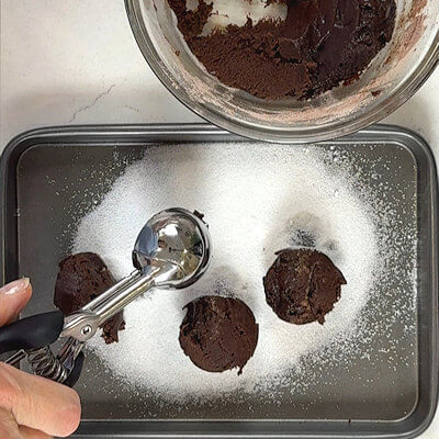 Step 5 - Use 2 spoons or a cookie/ice cream scoop to form 6 bolls and place them onto the granulated sugar.