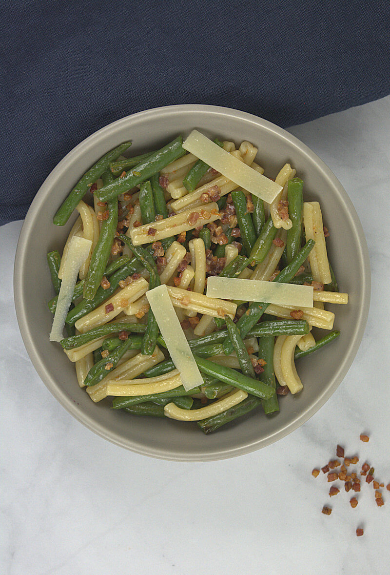 Green beans and pancetta pasta in a grey bowl.
