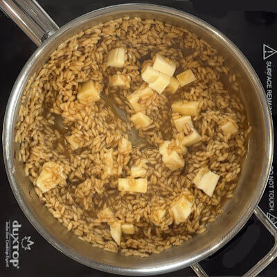 Step 5 - Cut the rind off the Taleggio cheese and cut it in small cubes, but leave a few slices aside for later. Once the rice has absorbed almost all the broth, add the cheese and mix until melted; the risotto will look creamy and delicious. Season with salt and pepper if needed.