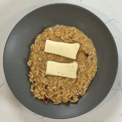 Step 6 - Transfer risotto onto 2 plates or bowls and place slices of reserved Taleggio slices on top; it will start melting instantly as the risotto is hot.The color alone will make you want to dig in.
