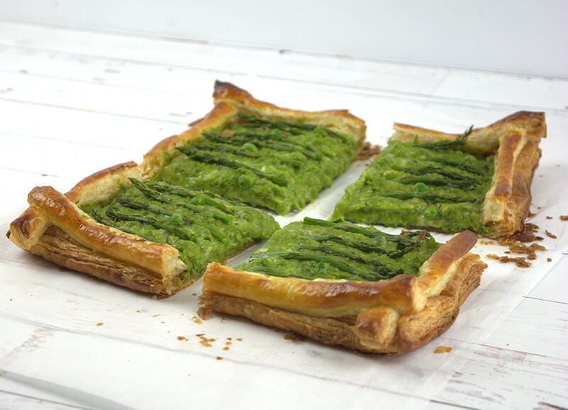 Asparagus Tart with Peas and Gruyere cut in four pieces.