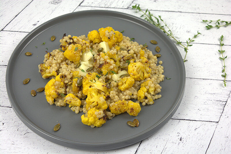 Cauliflower Couscous with Brie and Pepitas on grey plate