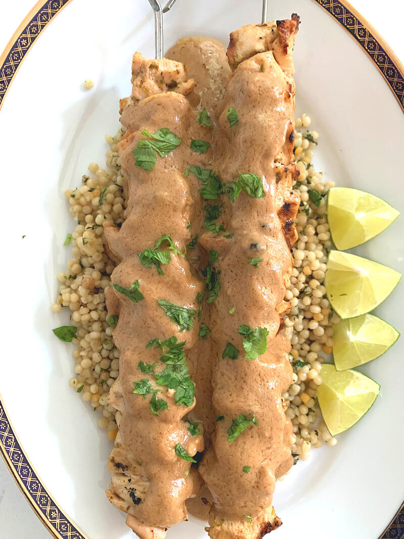 Close-up of chicken satay with peanut sauce.