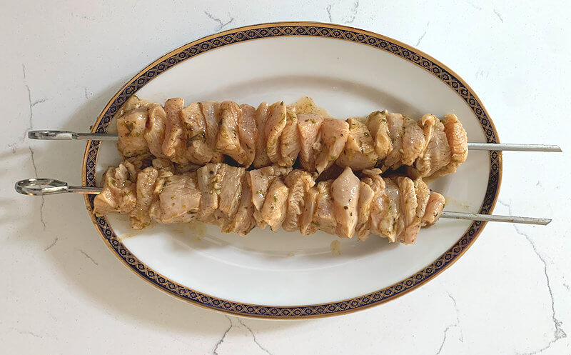 Step 2 - When you're ready to cook, in a grill pan or outside on the grill, thread the chicken pieces on skewers (discard the marinade).