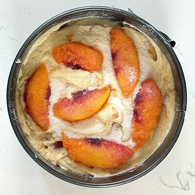 Step 6 - Spread batter into spring form pan (buttered) and place the peach slices on top. Sprinkle with some additional granulated sugar. 