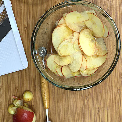 Step 2 - Cut the apple in half and take the core, stem and stamen, out of the center of the apple. Slice the apple very thinly. If you have a mandoline, use that. Don't slice it too thin, as you need to be able to roll it. Don't slice it too thick, as that may make rolling it into a rose more difficult. Try 1/16 - 1/8 inch thickness.Place all slices in a bowl, add lemon juice, light brown sugar, melted butter and salt and heat on high for 1 minute in a microwave. The apple slices should become pliable. If not heat a little longer.