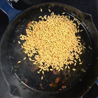 Step 2 - Transfer the chicken breast to a plate and add orzo to the skillet. Allow the orzo to toast a few minutes in the skillet.