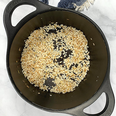 Step 1 - Heat butter in a Dutch oven or high walled skillet and and saute the onion (and garlic if you like) until translucent. Add the rice and stir until every grain is coated with the butter. Add the white wine and stir until all the wine is absorbed by the rice.